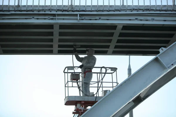 worker painting bridge, repair concept