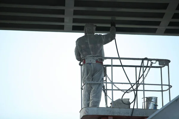 worker painting bridge, repair concept