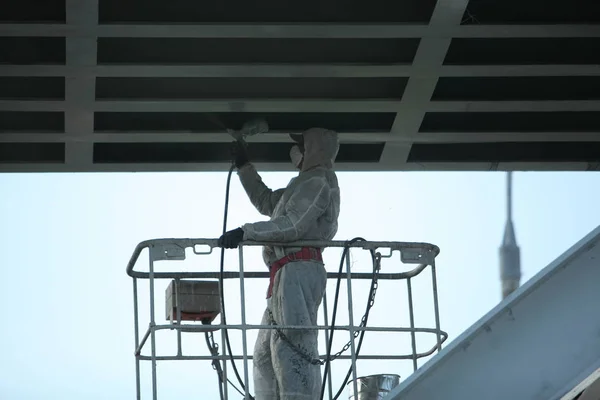 worker painting bridge, repair concept