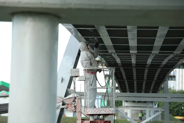 worker painting bridge, repair concept