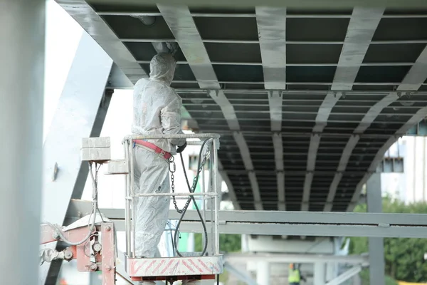 worker painting bridge, repair concept