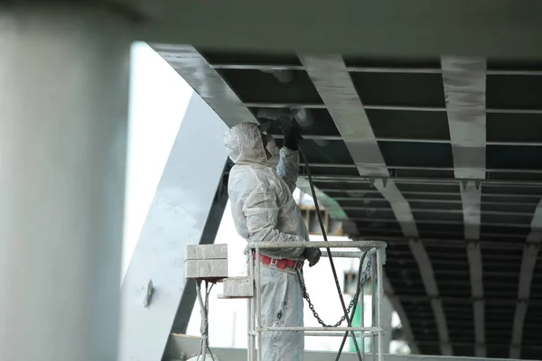 worker painting bridge, repair concept