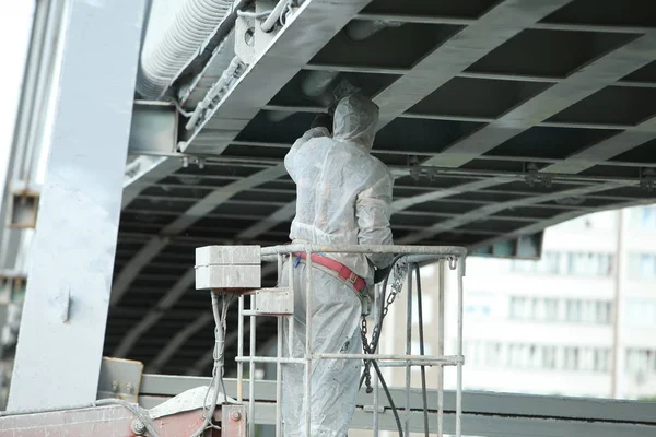 worker painting bridge, repair concept