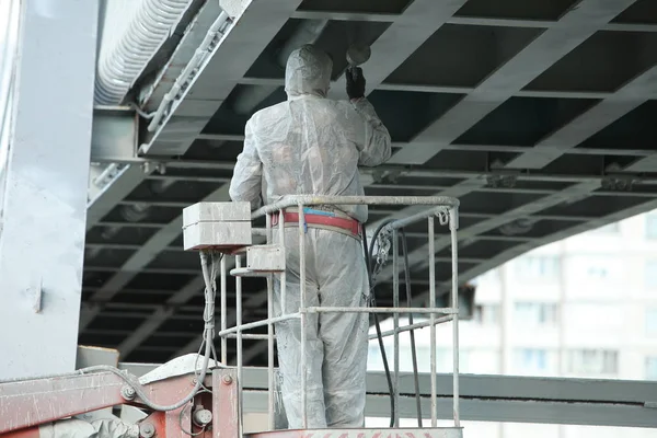 worker painting bridge, repair concept