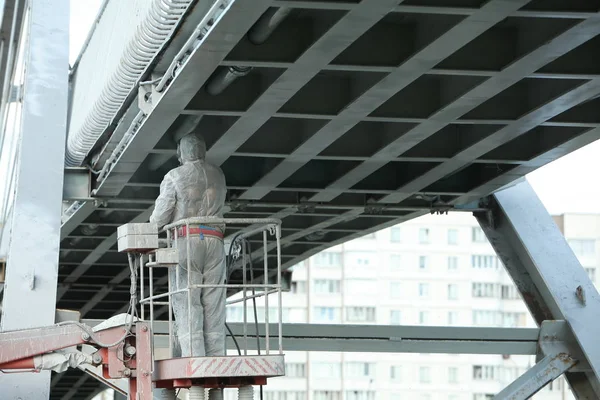 worker painting bridge, repair concept