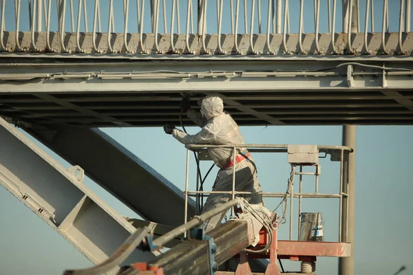 worker painting bridge, repair concept