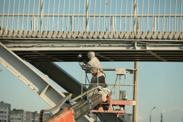 worker painting bridge, repair concept