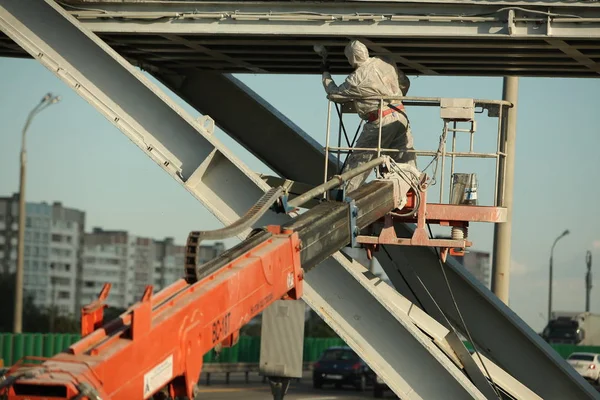 worker painting bridge, repair concept