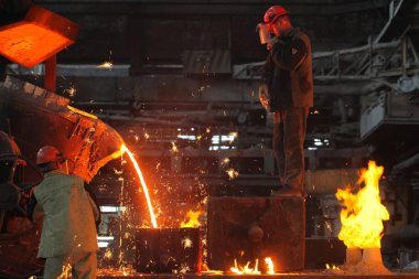 Belarus, Minsk, 2014. Work in the foundry. molten metal worker at a metallurgical plant clipart