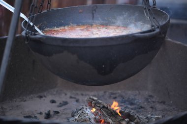 Büyük bir kazanda dışarıda ateşte yemek pişirmek.