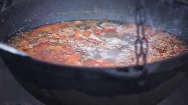 Büyük bir kazanda dışarıda ateşte yemek pişirmek. Asya yemekleri 
