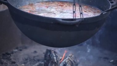 Büyük bir kazanda dışarıda ateşte yemek pişirmek. Asya yemekleri 