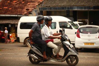 Asyalı bir aile gün boyunca yolda motosiklet sürüyor. Sri Lanka, Hikkaduwa, 2020