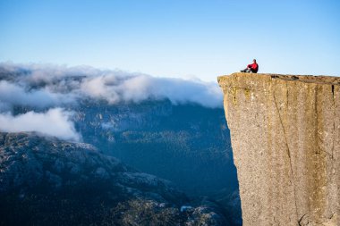 Preikestolen - Norveç'te rock şaşırtıcı. Bir uçurum bulutların üstünde adam. Müezzin Kayası, Ryfylke, en ünlü turistik Lysefjord üzerinde kuleleri