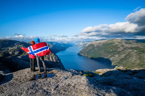 Lysefjord fiyort Preikestolen yolu üzerinden görüntüleyin. Turist çift Norveç bayrağı ile