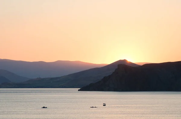 海と山の夏の風景です 尾根の背後に夕日 — ストック写真