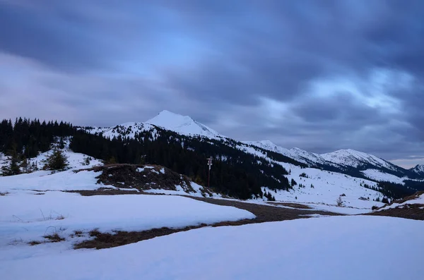 Winter landscape. Evening twilight in the mountains. The sky with beautiful clouds