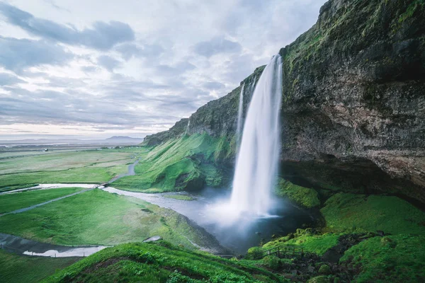 Seljalandsfoss waterfall. Summer landscape with cascade and a river. Famous tourist attraction of Iceland