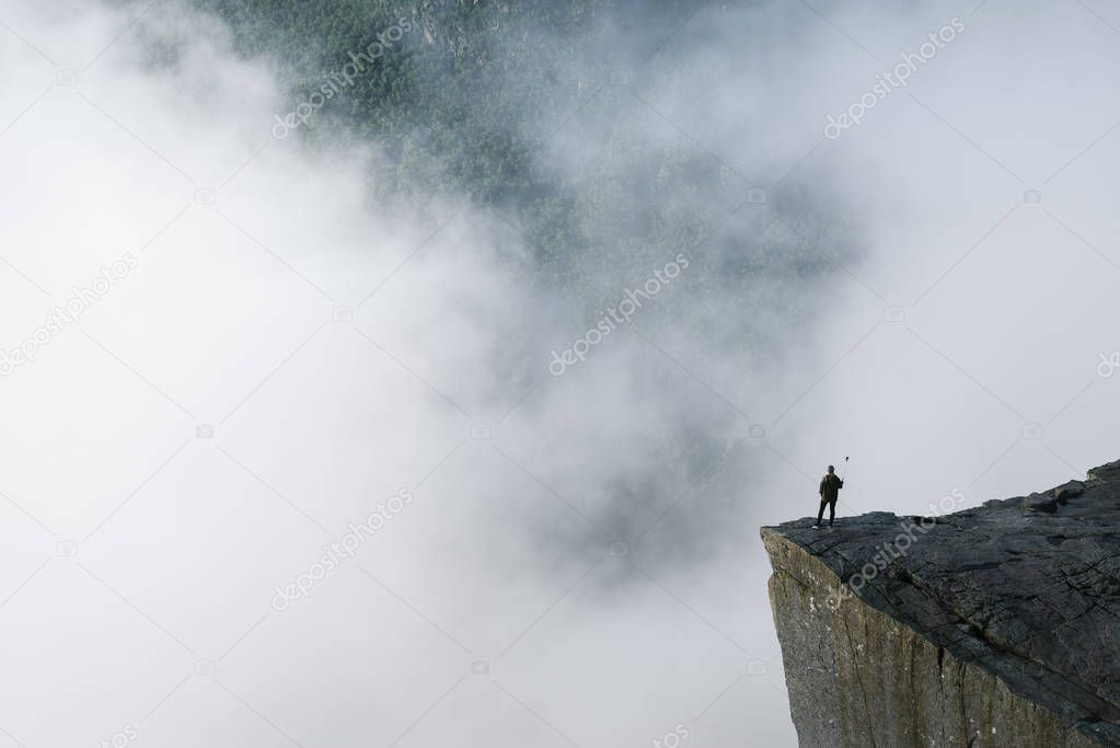 Norway, Forsand, rock formation Preikestolen, July 05, 2017: traveler does selfie on the cliff. Tourist attraction towers over the Lysefjord