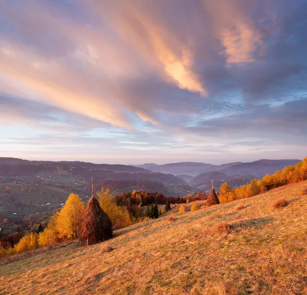 美しい空と雲と秋の風景 山の村の草原で乾燥干し草をスタックします 白樺の森の斜面 素晴らしい夜明け カルパティア山脈 ウクライナ ヨーロッパ — ストック写真