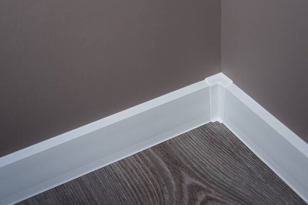 Белый пластиковый плинтус. Балкон после ремонта. Обои окрашены в коричневый
