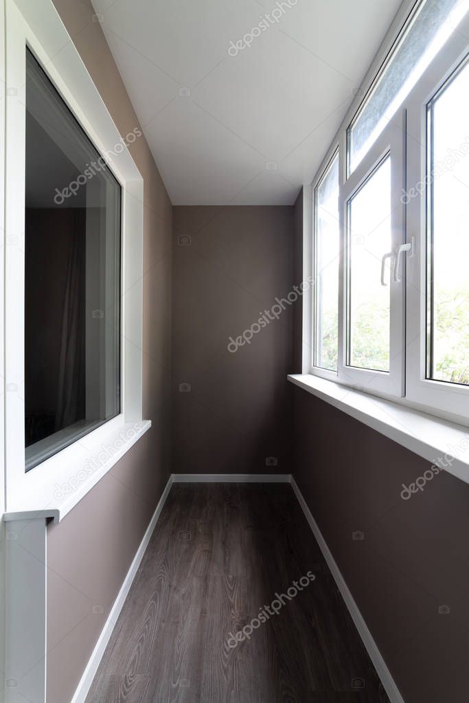 Balcony after repair. Walls with wallpaper are painted in brown