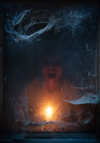 ハロウィーンのお祝いの背景 暗闇の中で キャンドルの光の中に直面します 古い恐ろしいクモの巣 — ストック写真