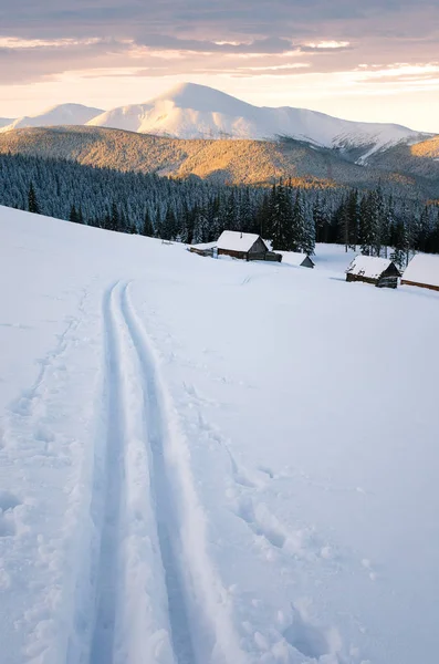 冬天风景在山里 雪的山坡上的滑雪跑道 美丽的日落在山脊上 雪中的木屋 — 图库照片