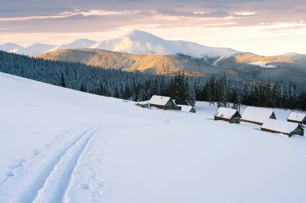 雪山在冬天与滑雪轨道 景观的小屋在雪地上的看法 夕阳的柔和光线 — 图库照片