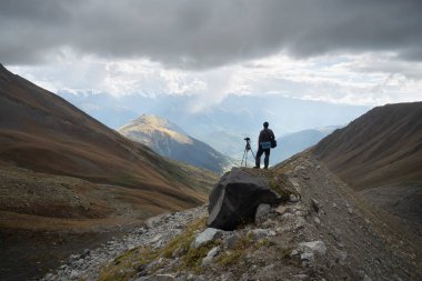 Manzara fotoğrafçı ile fotoğraf makinesi ve tripod dağlarda. Svanlar aralığı görünümünü. Ana Kafkas ridge. Samegrelo zemo Svaneti, Gürcistan 