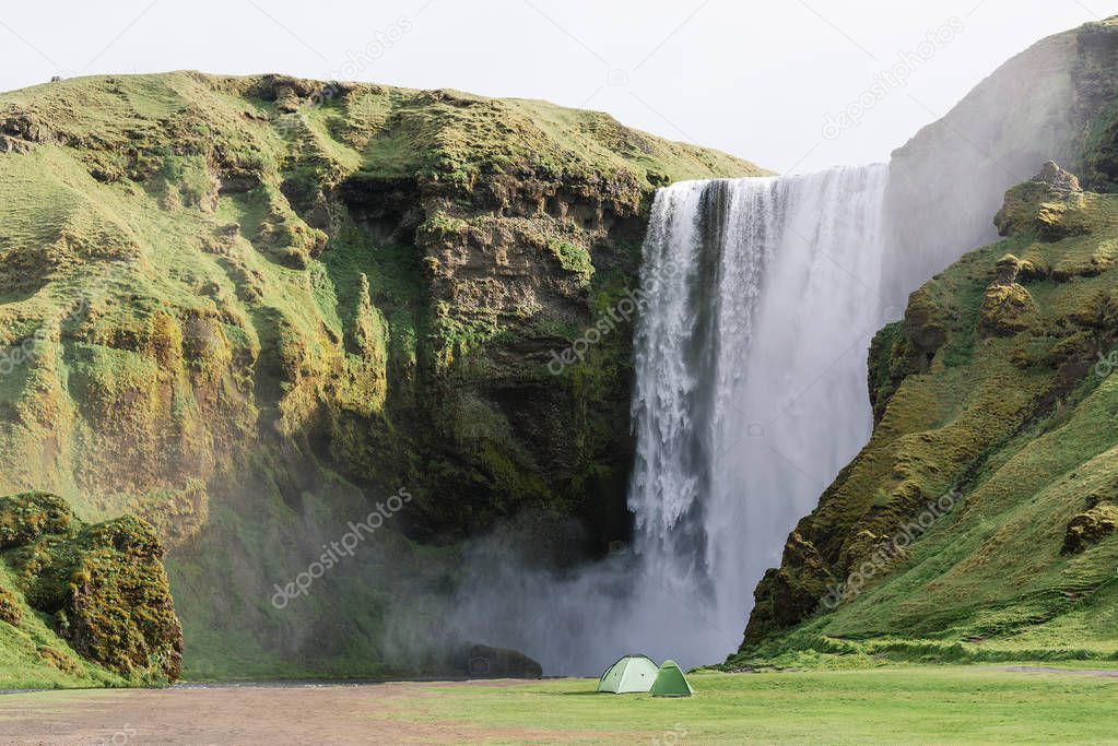 The Beautiful Skogafoss Waterfall in South Iceland. Famous landmark. Summer landscape on a sunny day. Camping with tents