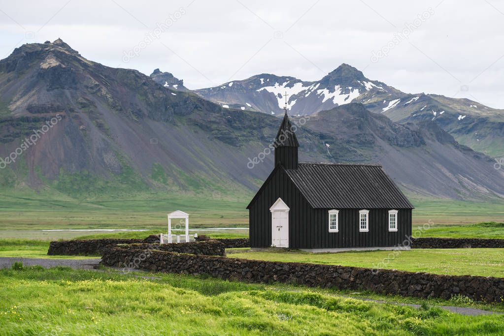 Budakirkja - black church in budir village. Summer landscape with a chapel and a mountains