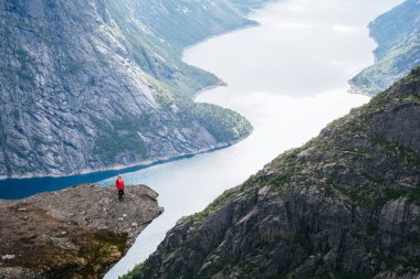 Trolltunga zam. Kız turist Ringedalsvatnet göl kenarında güzel bir manzara sahiptir. Yaz manzara dağ manzaralı