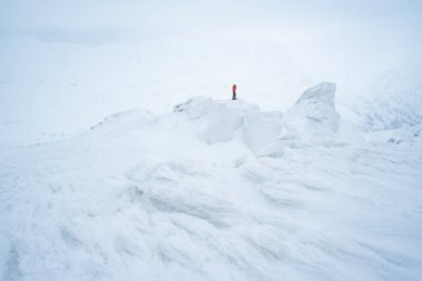 Kış karlı dağlarda trekking. Şiddetli hava ile kar ve bulutlar. Turist fotoğrafçı fotoğraf çeker