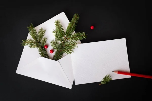 クリスマスや新年の挨拶手紙 モミの枝とホリーのベリーが付いている装飾 黒の背景にお祝いの組成物 コピー スペース フラット横たわっていた トップ ビュー — ストック写真