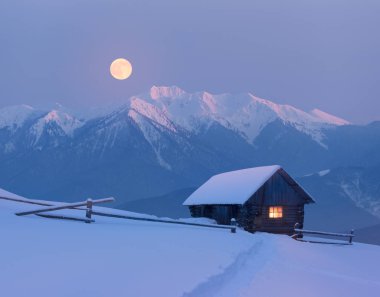 Dağlarda karlı bir evi olan bir Noel manzarası.