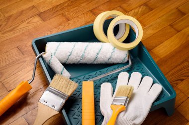 Boyama için temel araçlar: boya ruloları ve tepsi, fırça, maske bandı, eldiven, makas