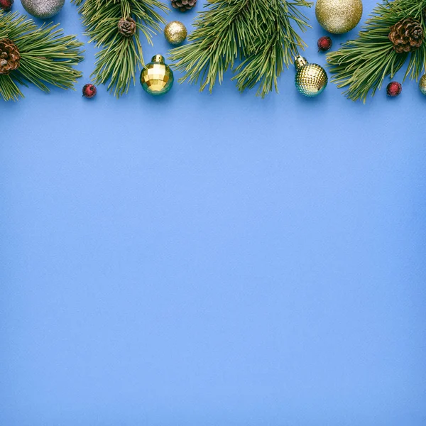 青い背景にモミの装飾が施されたスクエアクリスマスカード 広告テキストのコピースペースとのお祭りの境界線 トップビュー フラットレイアウト — ストック写真