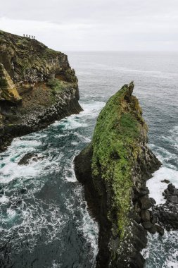 İzlanda 'nın engebeli kıyı şeridinde Atlantik Okyanusu üzerinde Londrangar Bazalt kayalıkları yükselen manzara manzarası