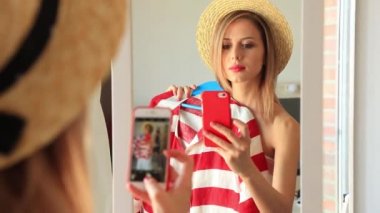 Sarışın kadının ayna, giysiler seçmek arkadan görünüş