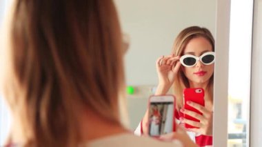 Sarışın kadının ayna, güneş gözlüğü seçiminde arkadan görünüş