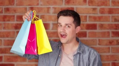 Renkli alışveriş torbaları tutan adam portresi