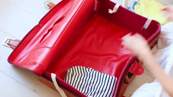 旅行バッグに服を整理する女性の手のトリミング ビュー — ストック動画