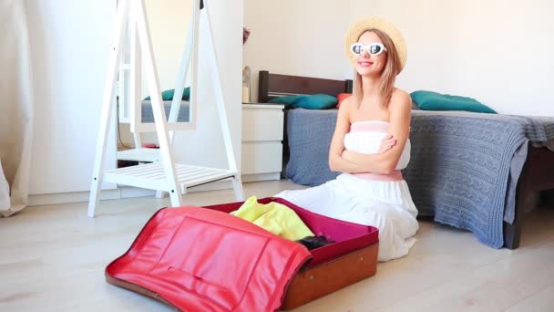 Katta Oturan Giysiler Seyahat Çantası Ambalaj Çekici Sarışın Kadın — Stok video