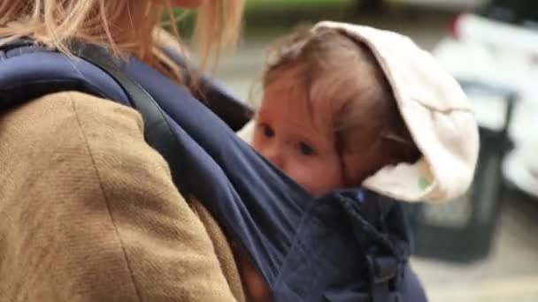 Lilla baby i hållaren med mamma på utomhus. — Stockvideo