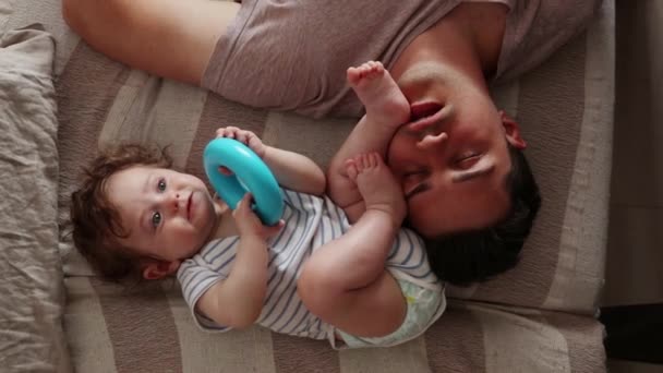 かわいいかわいい赤ちゃんの少年と父親のベッドで横になっています — ストック動画