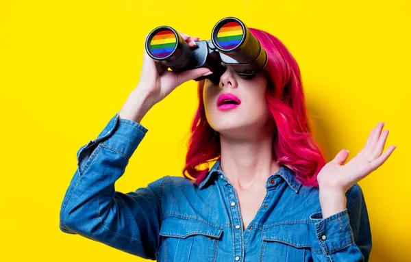 Ragazza in camicia blu con binocolo in mano con arcobaleno — Foto Stock