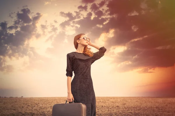 Meisje in zonnebril bij zonsondergang met tas — Stockfoto