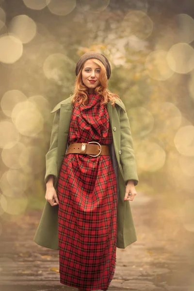 Young redhead girl in hat and coat at outdoor — Stock Photo, Image