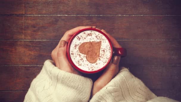 Manos sosteniendo la taza de café con forma de corazón — Vídeos de Stock